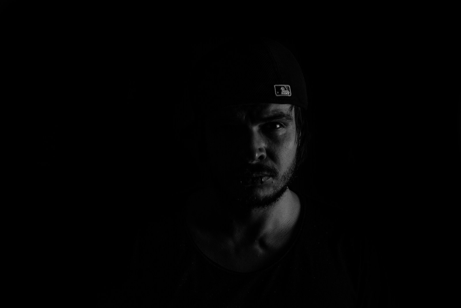 a man with a hat on in the dark